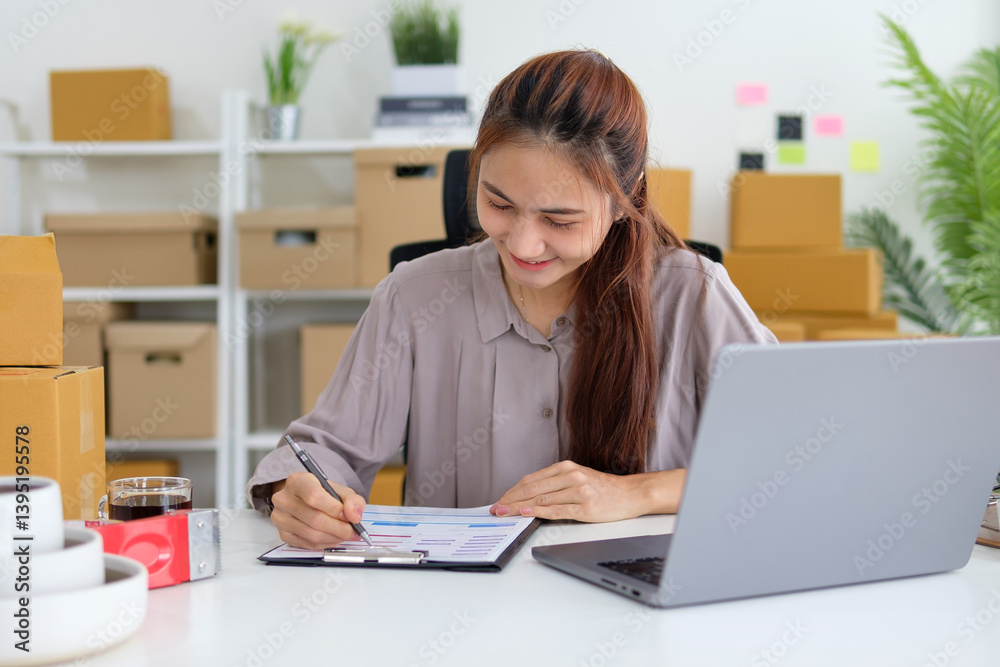 Female small business owner checking inventory or orders on a clipboard, surrounded by packaging boxes. Female small business owner checking inventory or orders on a clipboard, surrounded by packaging boxes.