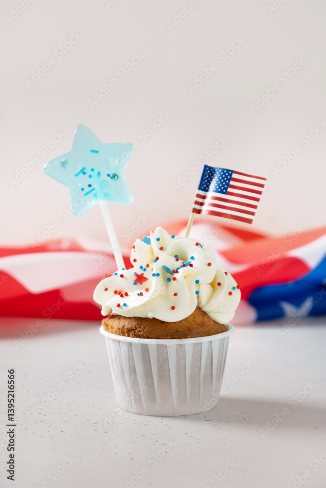 Traditional American vanilla sweet cupcake with festive decorations and USA flag on white background. Vertical format. Food and dessert for Patriotic Independence Day 4th of July.
