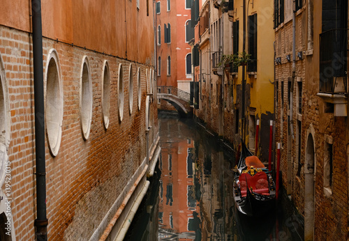 Fototapeta Naklejka Na Ścianę i Meble -  Typical narrow streets and canals between Colorful and shabby houses in Venice, Italy. Historical architecture in Venice, parked boats on the canals.