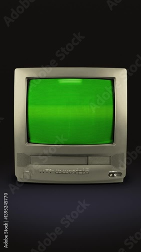 Old grey TV on a black background with a green screen. TV from the 90s with chromakey. CRT screen of a vintage TV with flickering and interference. Looping animation. Vertical video. 9:16 format.