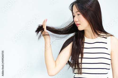 Closeup portrait of female model holding messy hair in hands, Combing with brush and pulls long hair, Daily preparation for looking nice, Long Disheveled Hair, Holding Messy Hair