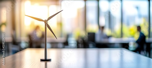 Obraz na płótnie Miniature windmill model placed on an office desk inside a bright, sunlit room, symbolizing clean energy, innovation, and eco-friendly thinking at work. w salonie