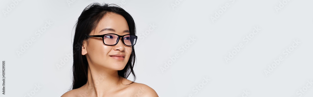 Young Asian woman wearing glasses gazes with a gentle smile, embodying grace and beauty Young Asian woman wearing glasses gazes with a gentle smile, embodying grace and beauty