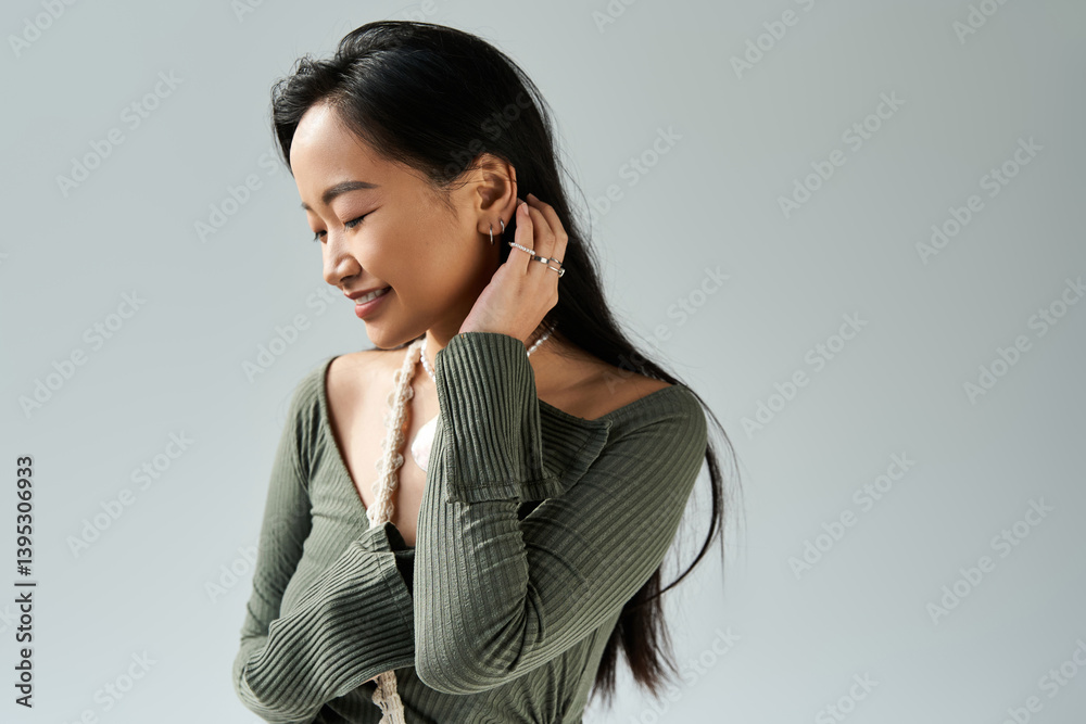 Young asian woman enjoying a moment of calm in a stylish green top indoors Young asian woman enjoying a moment of calm in a stylish green top indoors