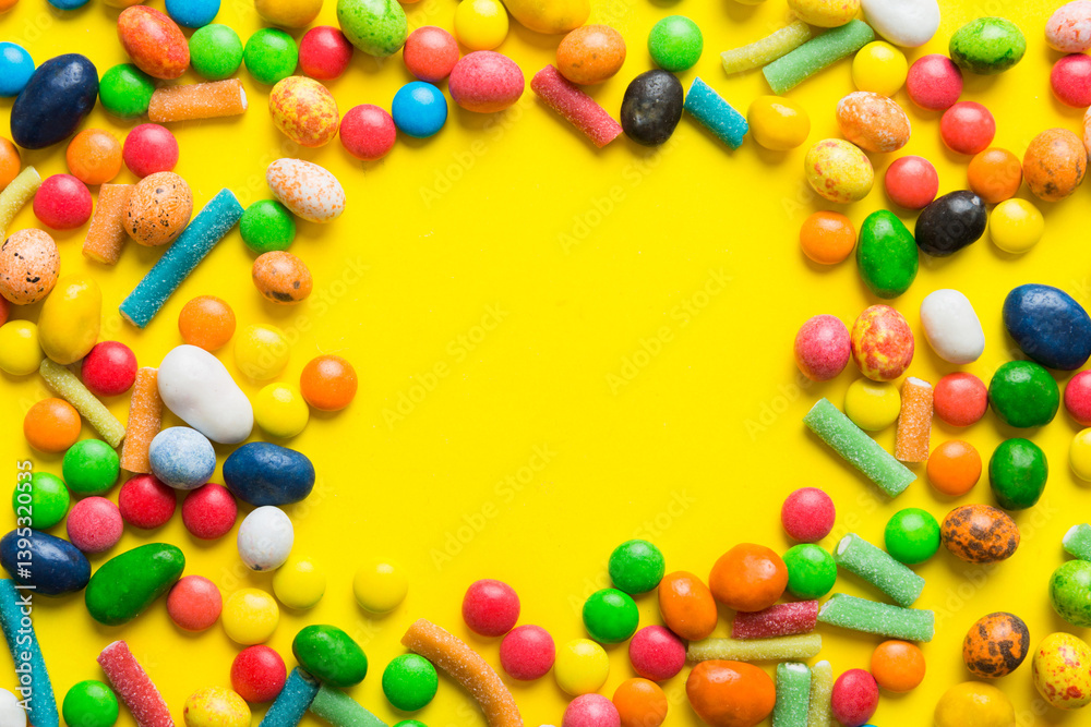 Obraz premium Mixed collection of colorful candy, on colored background. Flat lay, top view. frame of colorful chocolate coated candy