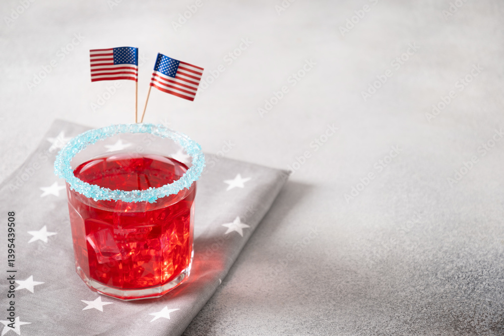 Patriotic red pomegranate margarita cocktail on blue background. Rim your festive beverages in blue sugar for popping for July 4th. Close up. Copy space.