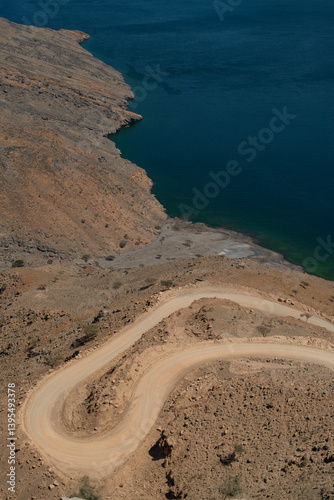 Obraz na płótnie Oman, 03-06-2025: aerial view of the winding road to Khor Najd, stunning fjord in Musandam Peninsula (Ruus Al Jibal) known for its natural beauty, peaceful setting and bioluminescence of its waters w salonie