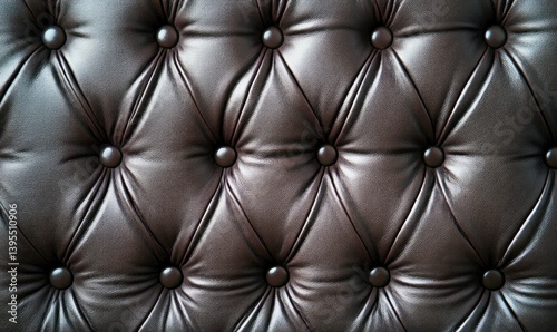 Detailed close-up of elegant dark brown leather upholstery with diamond pattern and buttons.