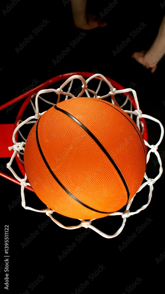 Detail of basketball ball hitting the basket, top view. Isolated on black background. Detail of basketball ball hitting the basket, top view. Isolated on black background.