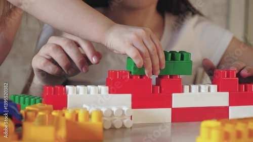 child play constructor with mother. red white colors. parent build together with kid from toy brick. teamwork. psychologist deals with child. happy family. group game constructor. chidhood dream.