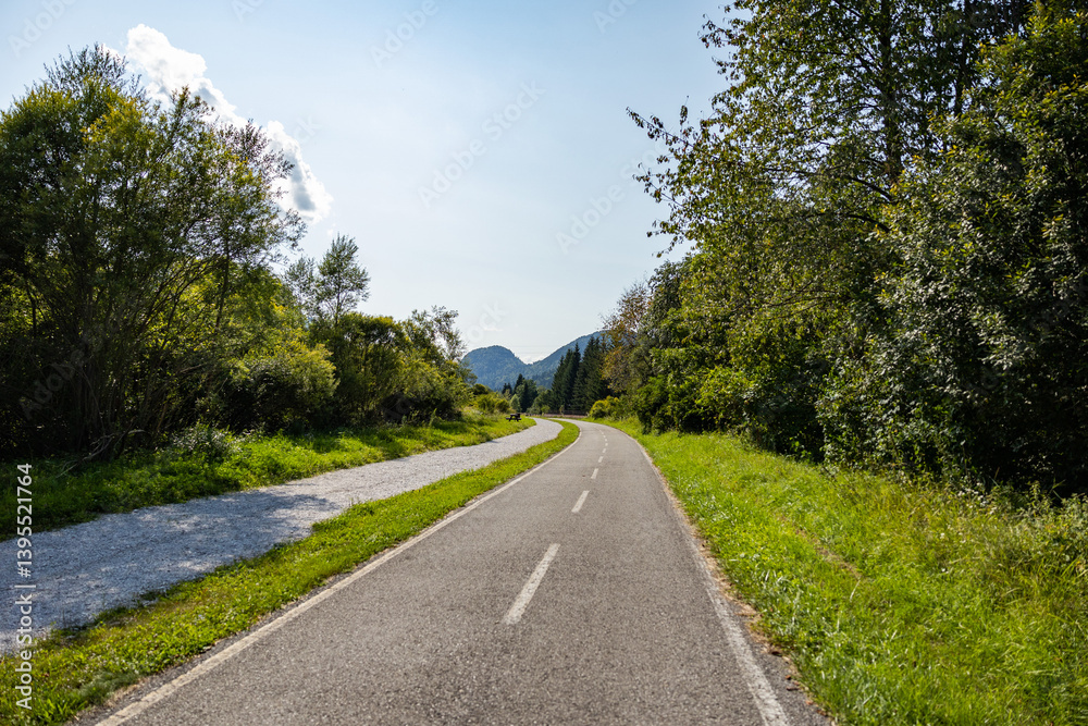 vista panoramica sulla lunga pista ciclabile Alpeadria, a fondovalle, in mezzo alle montagne, nel Friuli Venezia Giulia nord-orientale, di giorno, con cielo sereno, in estate