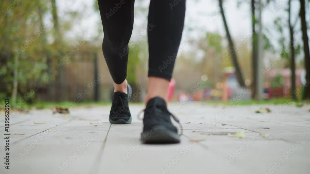 Close view of lady s leg in black sneakers set on ground, ready to run with hands down in a game park, focused athletic action shot in a park setting, preparing for a run or exercise session Close view of lady s leg in black sneakers set on ground, ready to run with hands down in a game park, focused athletic action shot in a park setting, preparing for a run or exercise session