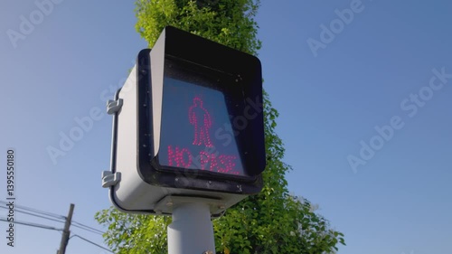 Close up of a level crossing traffic light indicating 'ATENCION NO PASE' (ATTENTION DO NOT CROSS) in Spanish on a sunny day