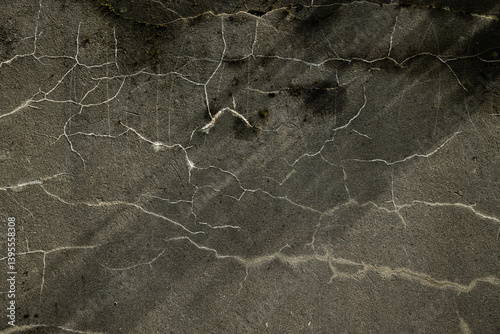 dettaglio in primo piano di una parete di cemento di colore grigio, con striature e strisce casuali e sottili bianche