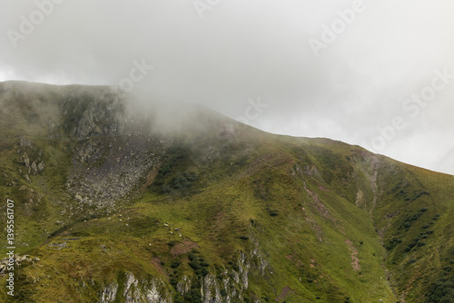 Obraz na płótnie vista dettagliata sulle cime ed i pendii erbosi e rocciosi di alcune montagne alpine nel nord Italia, di giorno, coperte parzialmente dalle nuvole, in estate w salonie