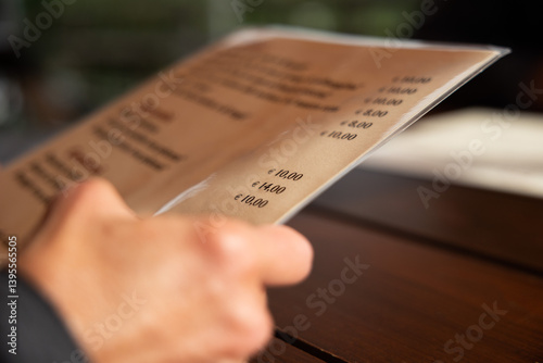 concetto di tenere in mano un menù di un ristorante. dettaglio sulla mano di un uomo adulto caucasico che tiene un menù