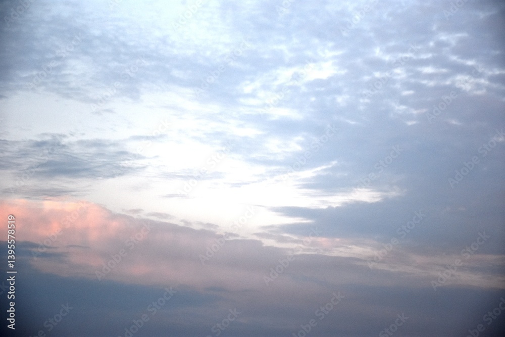 Obraz premium birds are flying in the blue sky to the east, surrounded by clouds near the moon.