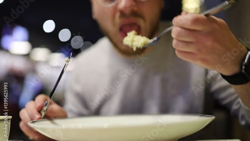 man eating salad with fork and knife