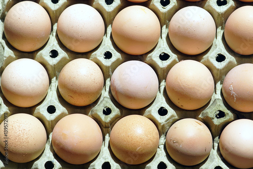 Farmer's market foods: medium-sized brown chicken eggs, photographed from above, lying in a recycled paper carton. One of the ingredients for baking. Diet Foods: a source of animal protein.