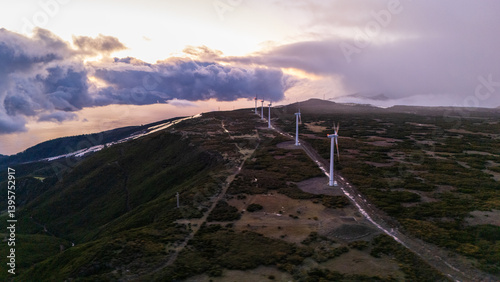 Wind turbines harnessing renewable energy at sunset on a picturesque hillside in a serene landscape