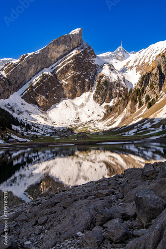 Beautiful reflections in the morning in spring at Seealpsee in the Alpstein with a view of the Säntis. Not far from the Säntis. Unique and impressive landscape in the Swiss Eastern Alps.