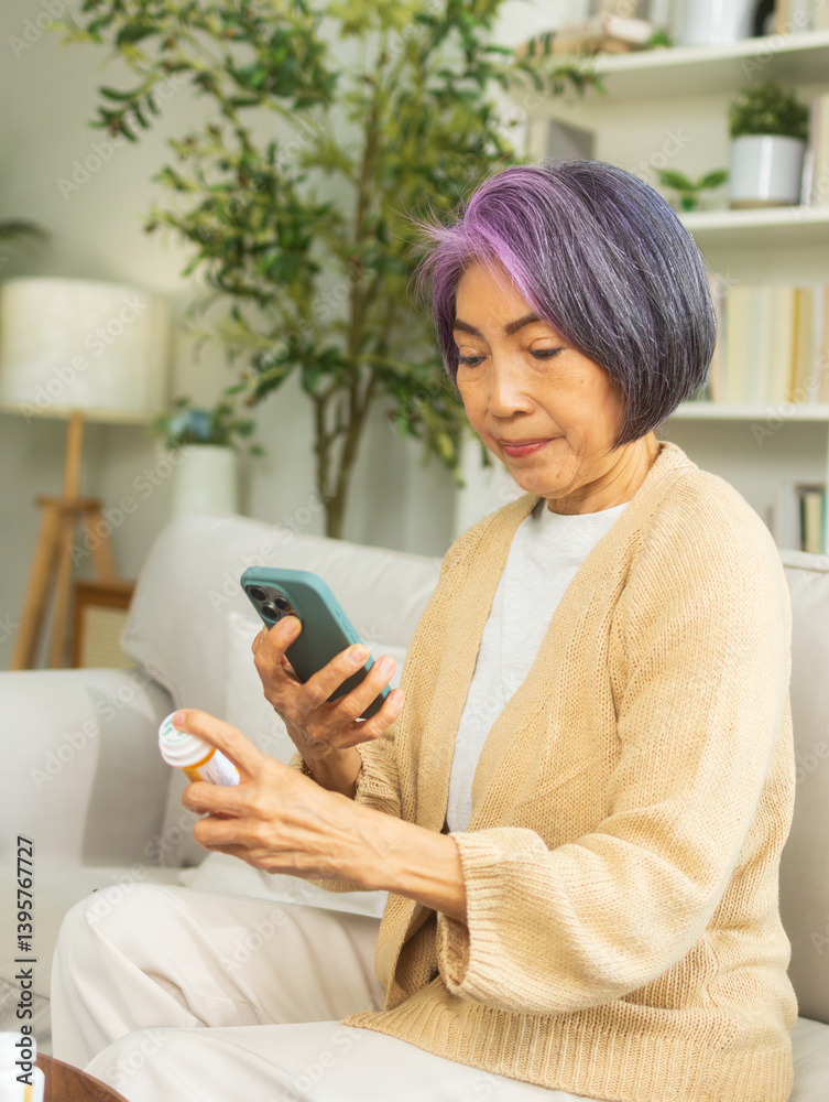 Asian senior hand holding bottle of pill checking prescription using mobile phone searching prescription and information online on internet, online video call with doctor in living room at home. Asian senior hand holding bottle of pill checking prescription using mobile phone searching prescription and information online on internet, online video call with doctor in living room at home.