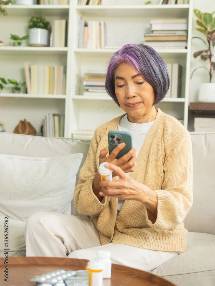 Asian senior hand holding bottle of pill checking prescription using mobile phone searching prescription and information online on internet, online video call with doctor in living room at home. Asian senior hand holding bottle of pill checking prescription using mobile phone searching prescription and information online on internet, online video call with doctor in living room at home.