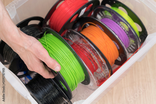 Colorful Assortment of 3D Printer Filament Spools Organized in a Storage Container