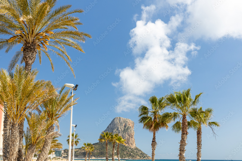 Calpe, Costa Blanca coast. Palm trees and Penon de Ifach hills. Sunny day. Spain