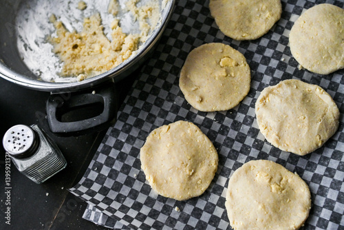 Arepa (colombian food) on table with pot, bowls and utensils, portraying culinary preparation.
