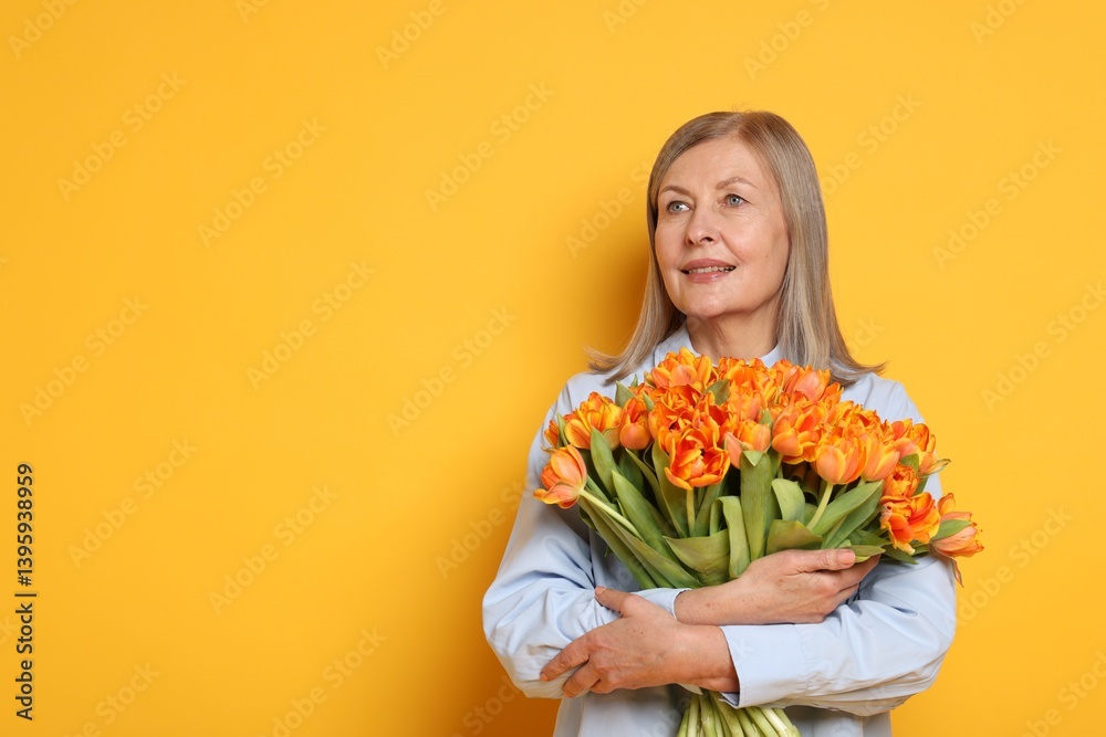 Smiling woman with bouquet of tulips on yellow background. Space for text Smiling woman with bouquet of tulips on yellow background. Space for text