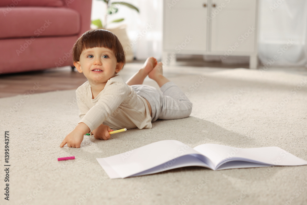 Cute little boy felt pen and sketchbook on floor at home, space for text Cute little boy felt pen and sketchbook on floor at home, space for text