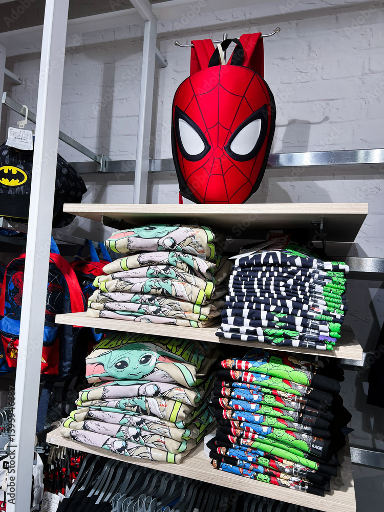 Obraz premium Stacked clothing shelves featuring superhero themed merchandise displayed for retail