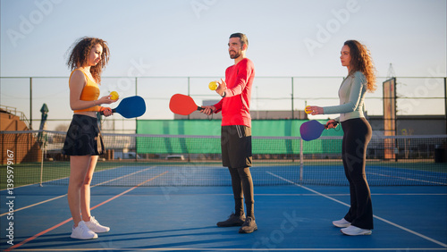 Obraz na płótnie Young adults teaching and learning how to play pickleball w salonie