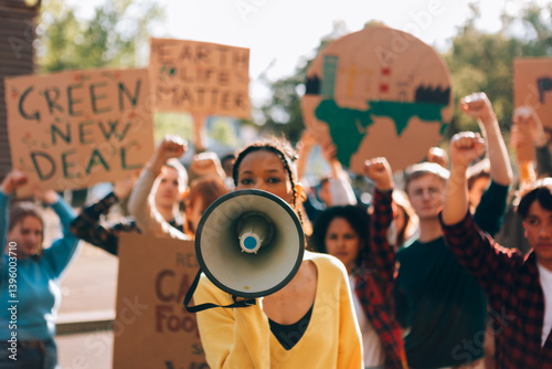 Young activist leading protest using megaphone for climate change and green new deal