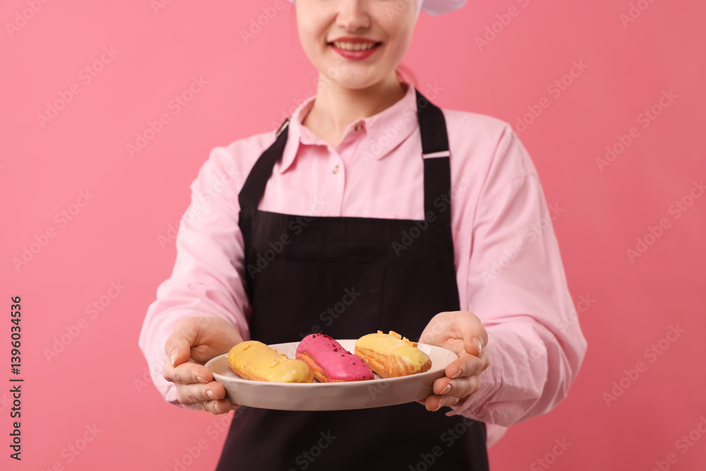 Confectioner holding delicious eclairs on pink background, closeup Confectioner holding delicious eclairs on pink background, closeup