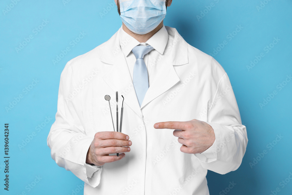 Professional dentist pointing at tools on light blue background, closeup Professional dentist pointing at tools on light blue background, closeup