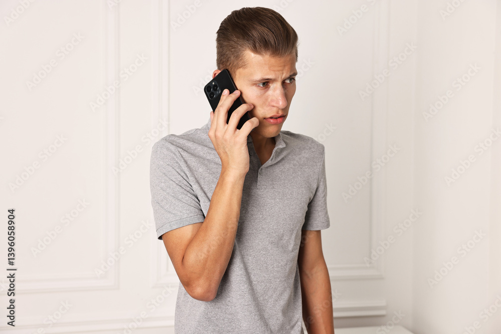 Frustrated man calling hotline for mental health help indoors Frustrated man calling hotline for mental health help indoors