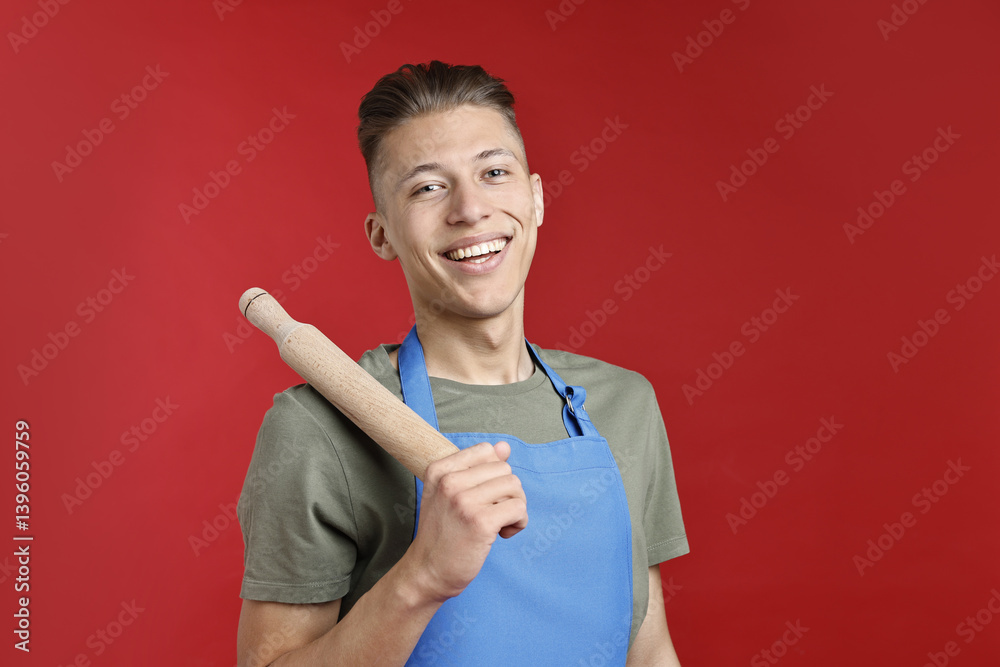 Happy man with rolling pin on red background Happy man with rolling pin on red background