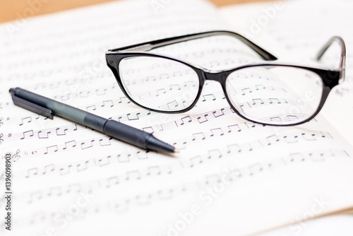 Glasses and pen on sheet music