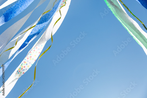Colorful paper crepe streamers flying against blue sky
