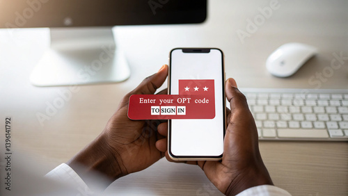 Person holding a smartphone displaying an opt code prompt with computer and keyboard on desk nearby