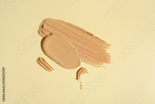 Composition with samples of liquid makeup foundation on color background