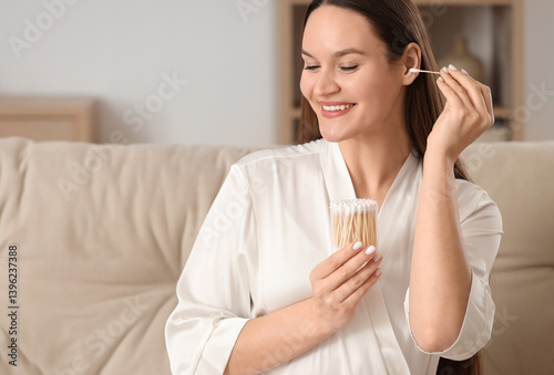 Young woman cleaning ears w...