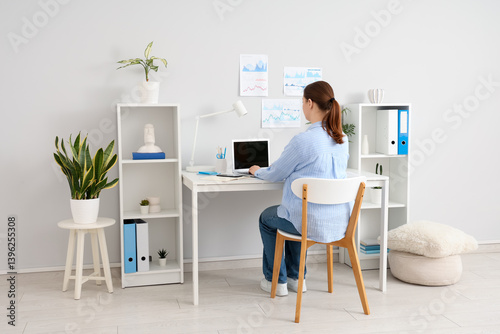 Young woman working with la...