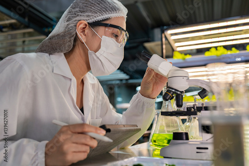 Fotografie A scientist in a laboratory conducts research using test tubes and a microscope