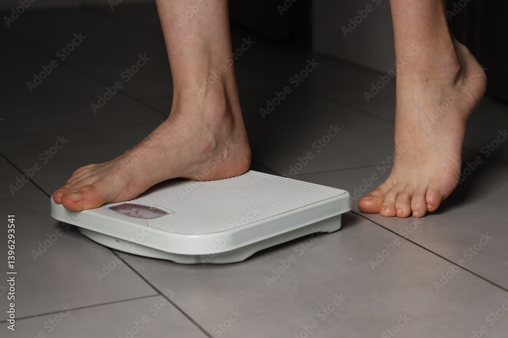 Woman on scales indoors, closeup. Bulimia problem