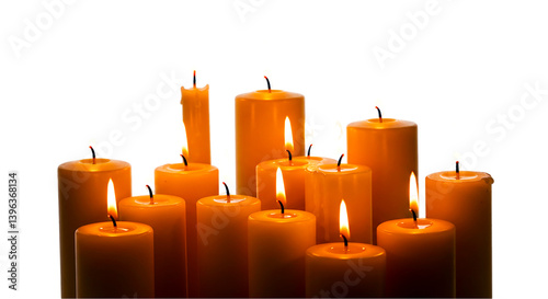 Group of lit candles with orange wax and flickering flames against a dark black background studio shot