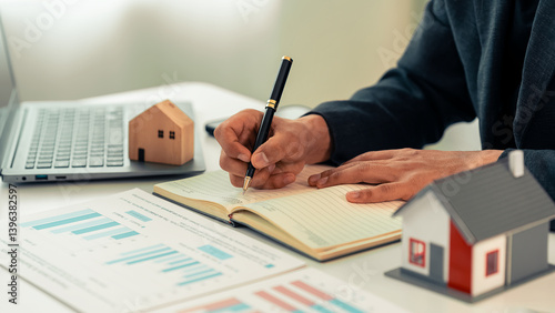 Foto Real estate agent uses calculator to calculate cost of home