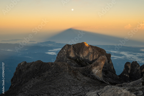 Moonrise over Mt.Kinabalu with the shadow of this mountain during sunrise. Mt Kinabalu is one of the highest mountain in South East Asia. 